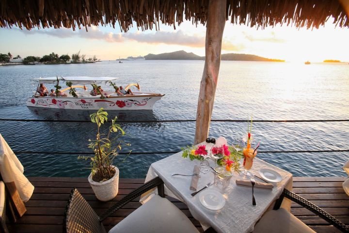 An outrigger canoe arriving at St James restaurant in Bora Bora